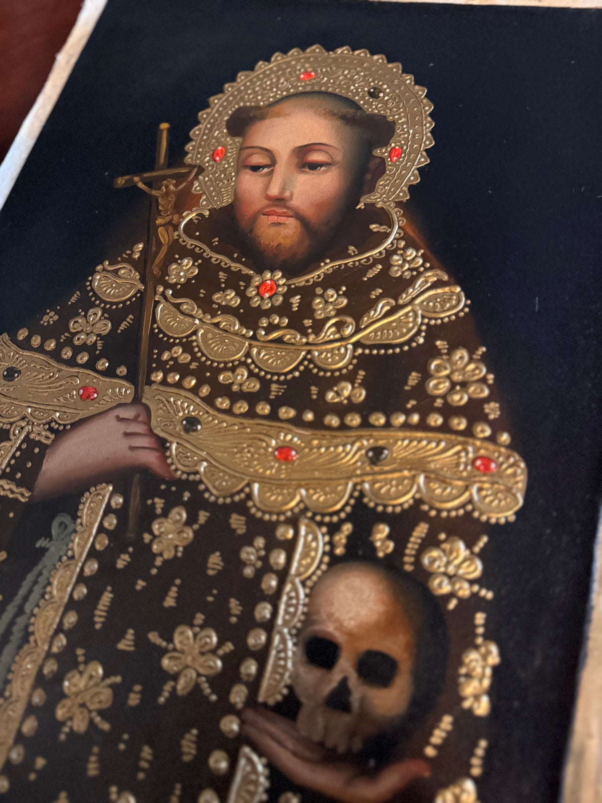 Detail of Saint John of the Cross painting with gold ornamentation